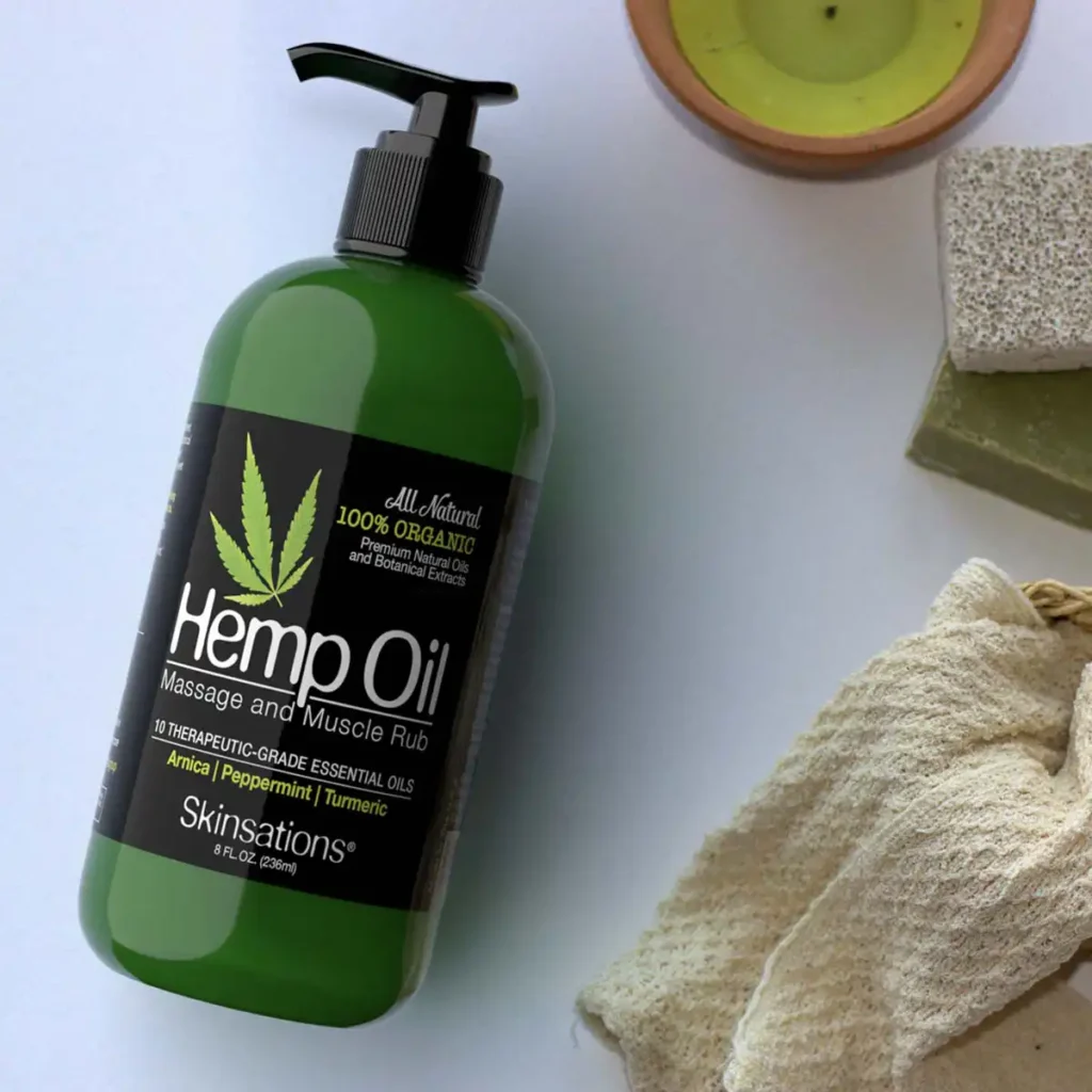 Top-down view of natural spa setting with hemp seeds, towel, candle, and stone on wooden surface — background for Skinsations® Hemp Massage & Muscle Rub.